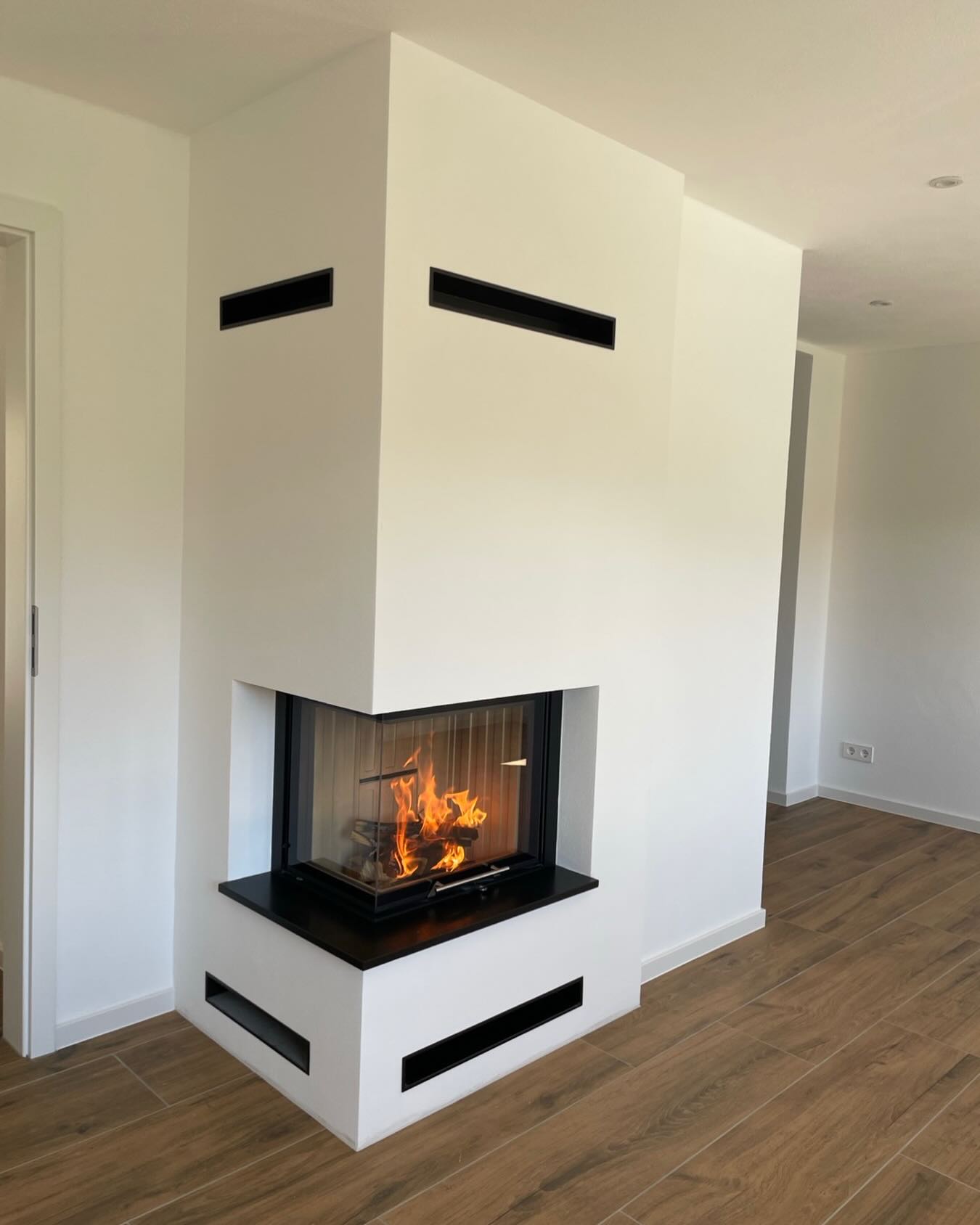 Individuelle Kaminanlage mit einem Kamineinsatz der Firma Spartherm, Kaminscheibe hochschiebbar.