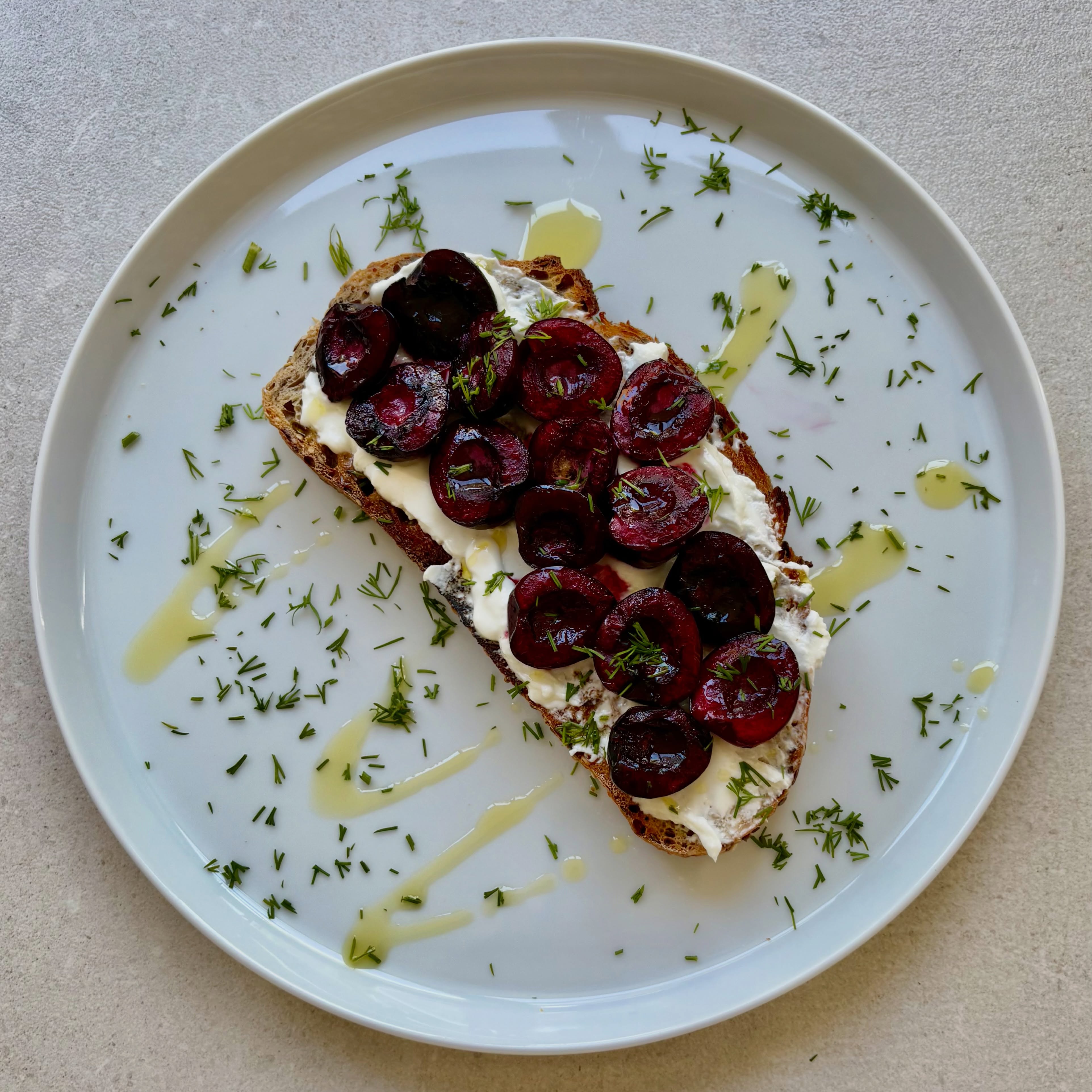 This was a bottom of the fridge lunch, inspired by the fabulous @boroughchef - who used cherries with goats cheese earlier this week. Decided to roast the cherries for 10 minutes with a drizzle of olive oil and a little seasoning, as they were slightly past their best. Had some goats cheese leftover from a beetroot, orange and goats cheese salad I’d had a few days ago, so spread that over a thick slice of toast. Topped with the roasted cherries, a drizzle of honey and some finely chopped dill. Blinking delish!
#cherries #cherryrecipes #thingsontoast
